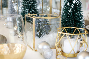 Simple and Modern Christmas Dining Table Ideas - BHG Live Better Gold Lanterns filled with mini bottle brush trees and fake snow