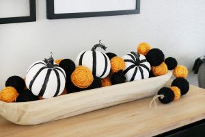 Simple Black & White Halloween Decor - Grab a decorative wood bowl and fill it with cute pumpkins and a textured garland.