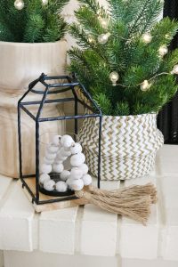 Black & White Casual Boho Christmas Decor - Fill lanterns with wooden casa beads and twinkle lights.